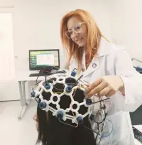 Investigadora en un laboratorio de neurociencia registrando la actividad cerebral de una participante